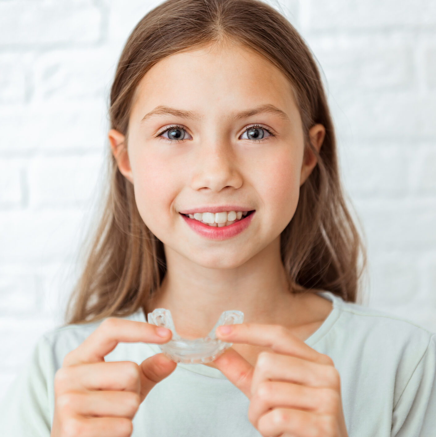Smiling Child Girl With Perfect And Healthy Teeth Using Removable Braces Or Aligner For Straightening And Whitening Teeth. Orthodontic Treatment For Correction Of Bite